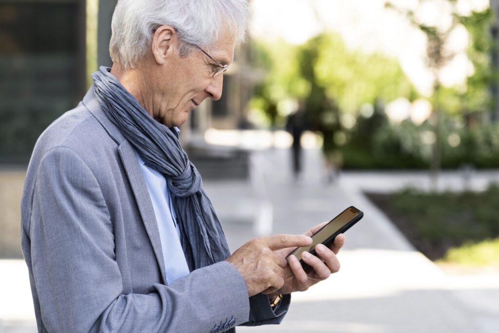 homme senior utilisant un téléphone mobile avec localisation GPS