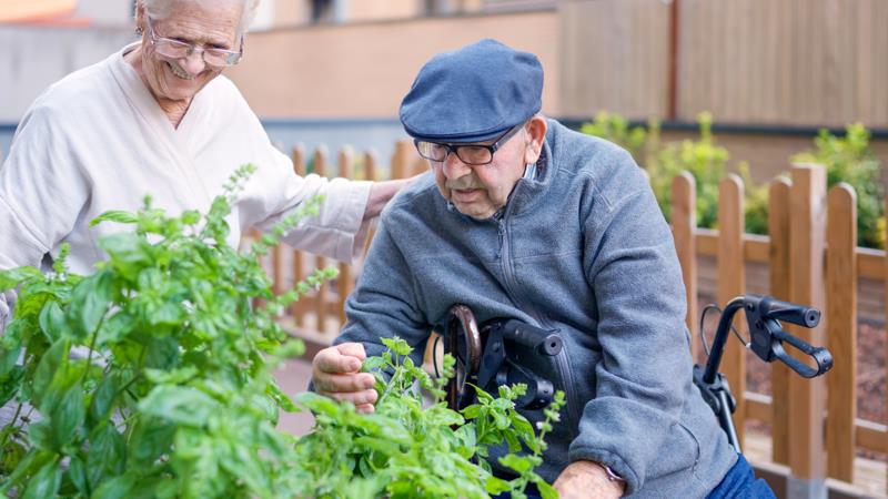 Deux personnes âgées dans le jardin d'une maison de retraite Alzheimer