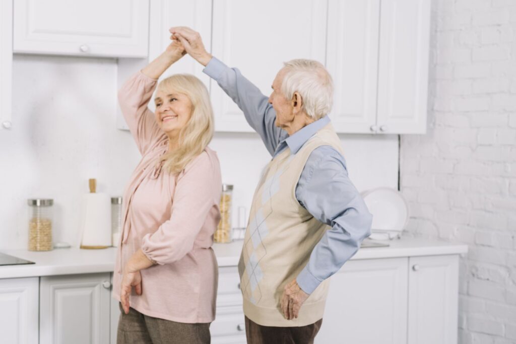 couple de seniors Alzheimer à domicile pratiquant la danse