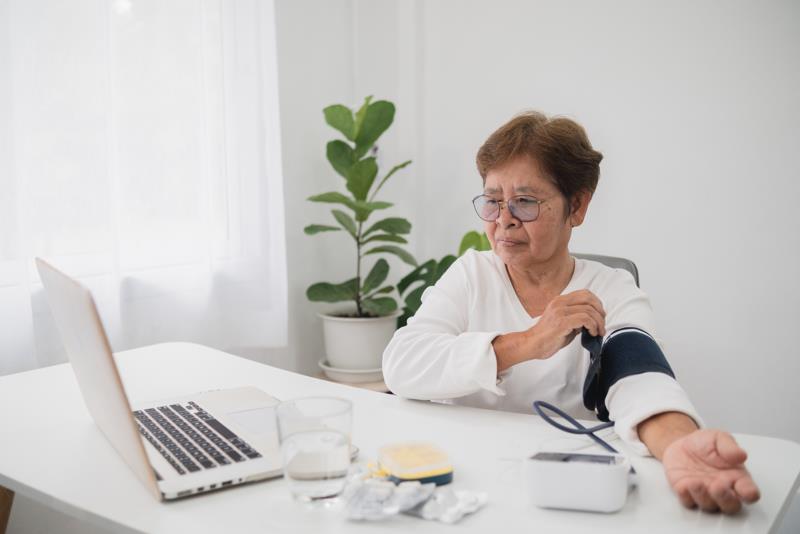 Personne âgée vérifiant sa tension dans le cadre d'une consultation en télésurveillance médicale