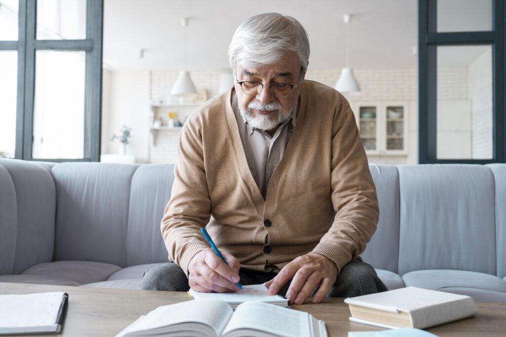 homme senior faisant une liste des établissements de retraite l'intéressant