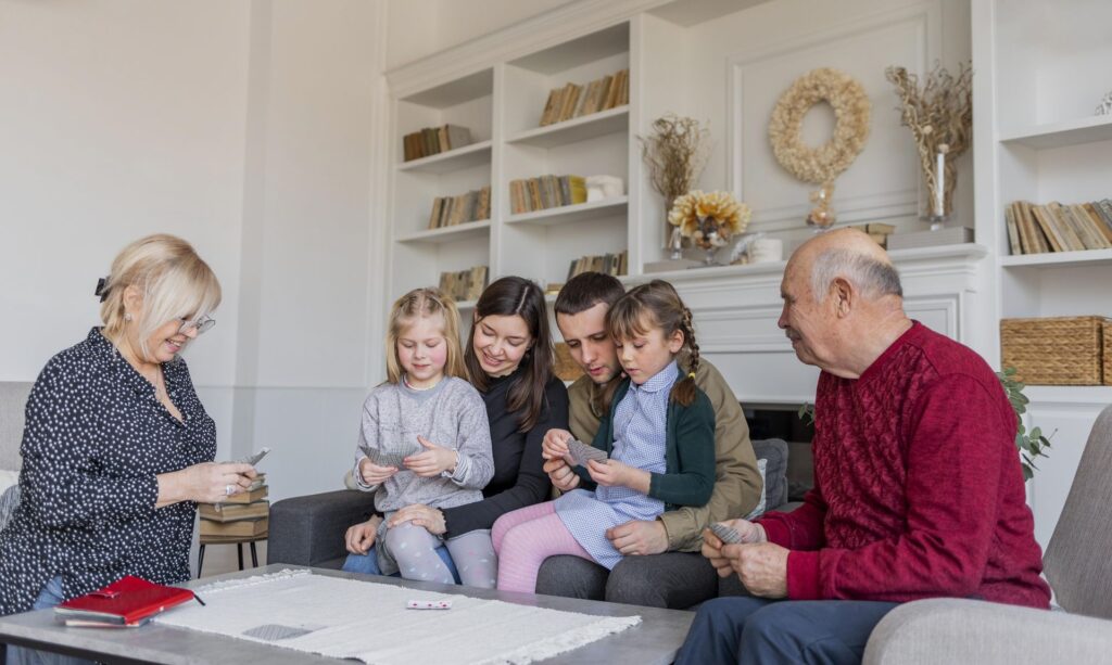 senior qui perd la mémoire jouant en famille à un jeu de cartes