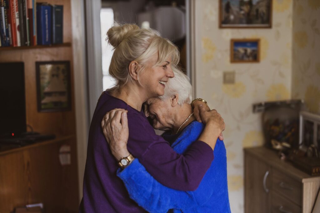 Mère âgée et sa fille qui s'enlacent