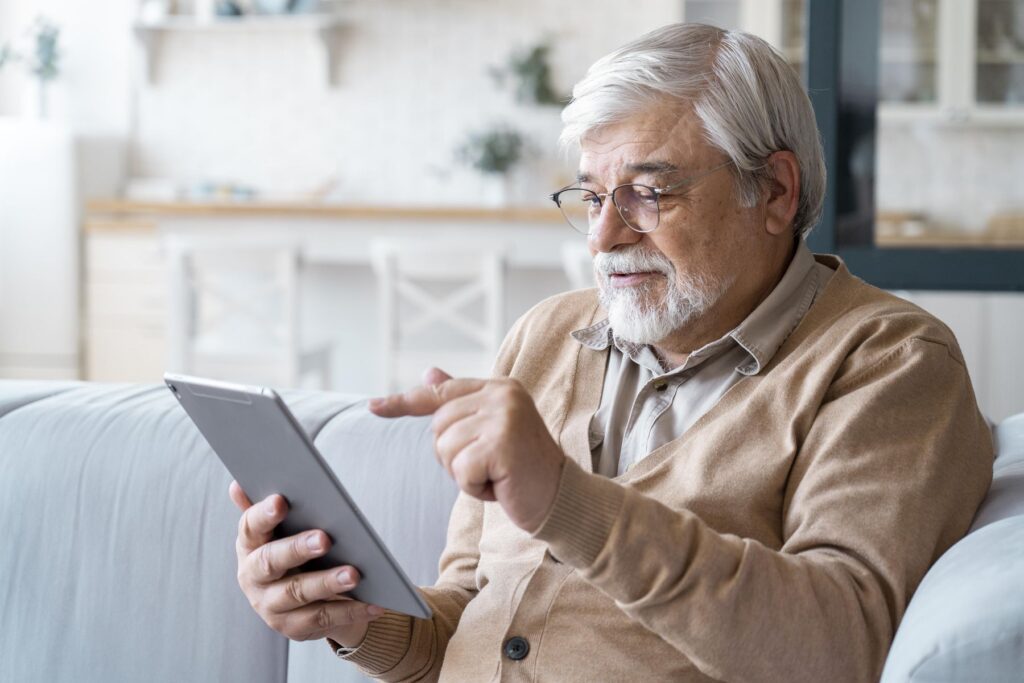 homme senior utilisant une tablette simplifiée