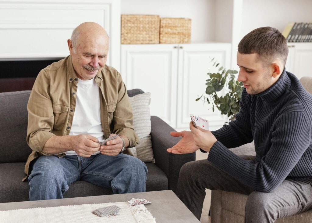 personne âgée jouant aux cartes avec son petit fils