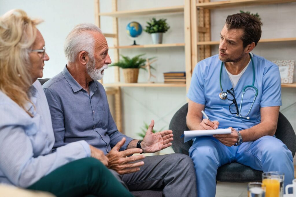 couple de seniors discutant avec un médecin durant une visite d'EHPAD